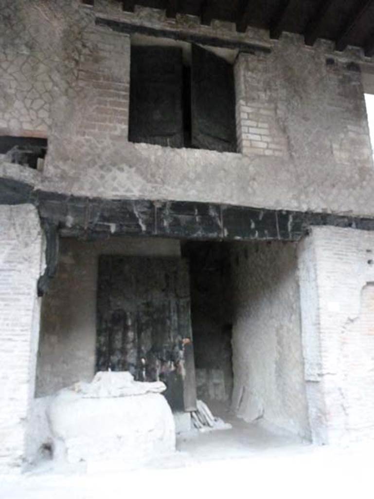 Decumanus Maximus, Herculaneum, September 2015. Building on north side of the Decumanus Maximus, doorway numbered 4 with the remains of door and window shutters in carbonised wood. Found on the left, partially buried in the volcanic debris and left in situ, was a large wooden chest with lid and rear in iron, inside of which were some bronze pots/vases.
See Camardo, D, and Notomista, M, eds. (2017). Ercolano: 1927-1961. L’impresa archeologico di Amedeo Maiuri e l’esperimento della citta museo. Rome, L’Erma di Bretschneider, (p.280-81, Scheda 56)
According to Guidobaldi,the pots/vases were made of glass.
See Guidobaldi, M.P, 2009: Ercolano, guida agli scavi. Naples, Electa Napoli, (p.118). See Pesando, F. and Guidobaldi, M.P. (2006). Pompei, Oplontis, Ercolano, Stabiae. Editori Laterza, (p.385-6)
Found on the ground floor of Shop No. 4, on 8th January 1968 (New excavation on Decumanus Maximus), were – Intaglio su corniola: Eros and Anteros, now in Naples Archaeological Museum, inv. no. 158866. (Pannuti 1983, 36). Intaglio su corniola: Cavaliere, now in Naples Archaeological Museum, inv. no. 158867. (Pannuti 1983, 163).
See Pagano, M. and Prisciandaro, R., 2006. Studio sulle provenienze degli oggetti rinvenuti negli scavi borbonici del regno di Napoli. Naples: Nicola Longobardi.(p.232).
See Pannuti, U. 1983. Museo Archeologico Nazionale di Napoli. Catalogo della collezione glittica. Rome. Vol.1.